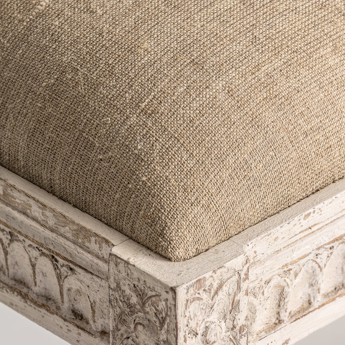 The Cepoy bed foot stool, in a soft cream washed finish, captures the rustic serenity of Provenzal design. Expertly chiseled from mango wood and paired with a harmonious blend of cotton and linen, it offers a tactile experience that's both comfortable and aesthetically pleasing
