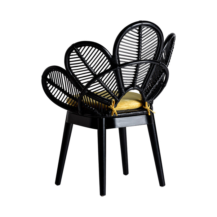 The "Lluc" armchair is a black-colored, kitsch-style seating option. It is crafted from rattan and features a combination of cotton and foam for enhanced comfort. The product is designed to be removable, allowing for easy maintenance and cleaning