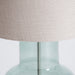 This is a table lamp with a classic design that features a natural color scheme of grey and silver. The lamp is crafted from natural materials such as glass, iron, and linen