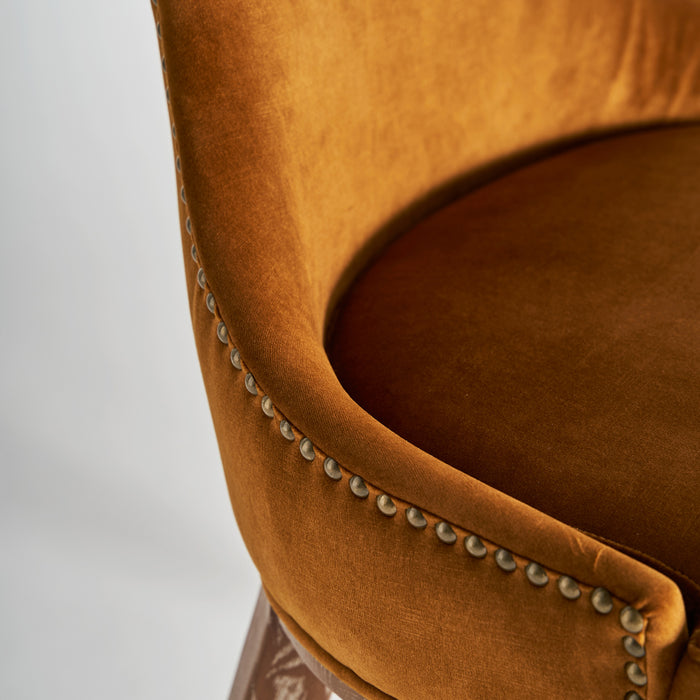 Indulge in the vintage allure of the Dozza Chair, featuring a warm ochre color that adds a touch of elegance to any space. This chair is meticulously crafted with a combination of premium fabric upholstery, sturdy birch wood, and plush foam padding, ensuring both comfort and durability